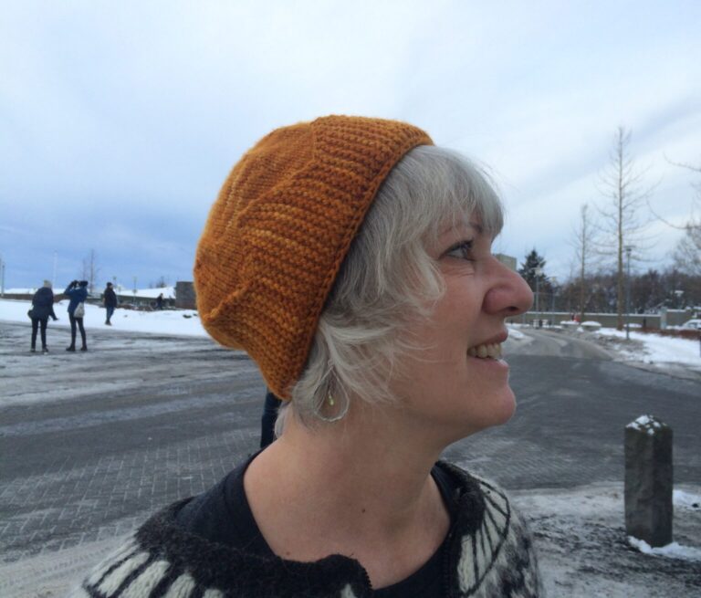 Deb Nolan wearing a golden knit hat with band that is reminiscent of a crown